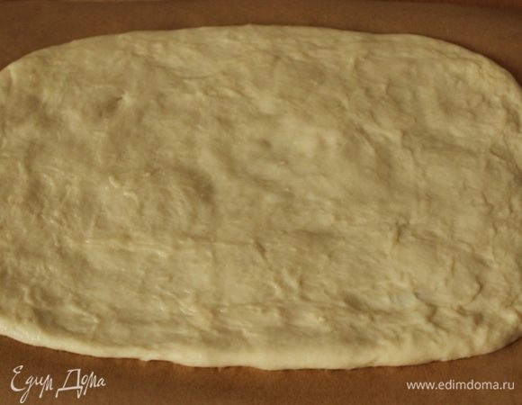 Поверхность стола немного смазать растительным маслом, выложить тесто. Слегка присыпать мукой, раскатать в тонкий пласт размером 20 х 30 см. Дать полежать тесту 10 мин. Я раскатывала сразу на листе пергамента, чтобы потом сразу переложить на противень.
