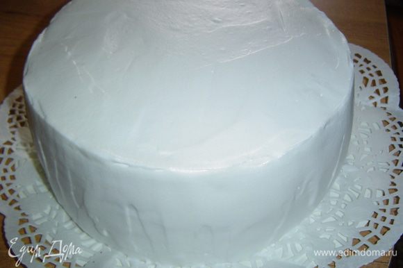 Когда торт пропитается кремом, покрываем его взбитыми сливками и аккуратно разравниваем.
