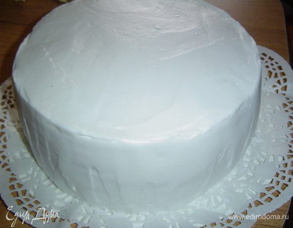 Когда торт пропитается кремом, покрываем его взбитыми сливками и аккуратно разравниваем.