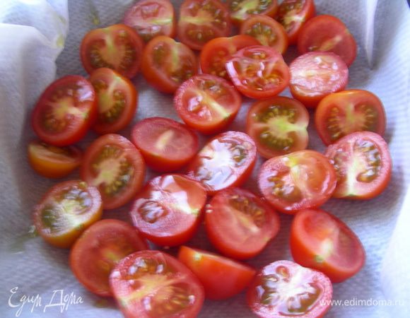 Черри разрезаем напополам, выкладываем в форму для запекания (на бумагу для выпечки), взбрызгиваем оливковым маслом и запекаем в духовке 10 минут.
