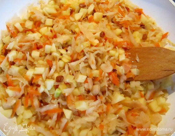 Изюм слить и обсушить. К луку добавить изюм, нарезанные яблоки, капусту перемешать и протушить в течение 15 мин.