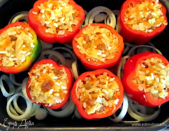Аккуратно наполнить перчики смесью. Оставшийся лук порезать кольцами.
Противень смазать растительным маслом, положить кольца лука. Сверху выложить перцы и влить бульон (у меня куриный).