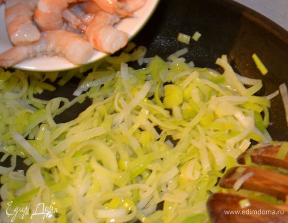 Как только лук станет мягким, добавить очищенные креветки. Обжариваем вместе луком совсем недолго, иначе могут стать жесткими. Снять сковроду с огня. 