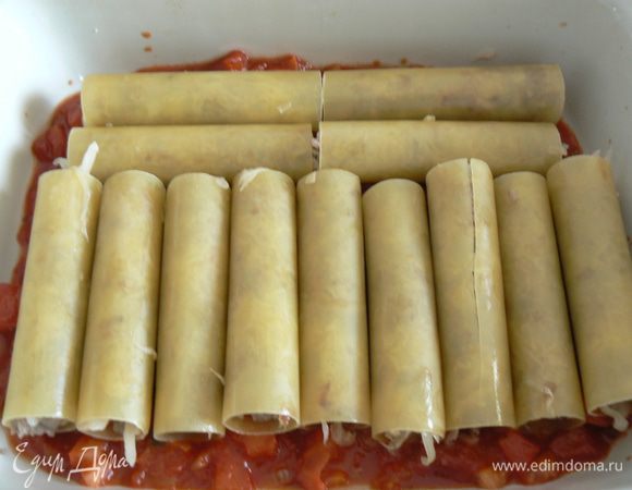 в форму для запекания поместить небольшое количество соуса, затем начиненные каннелони