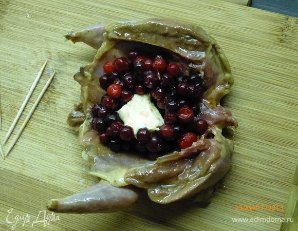 Через час перепелов можно фаршировать.К бруснике добавляем 1 ст.л. сахара без горки (если используете замороженную - заранее разморозить). Раскрываем тушку, кладем внутрь 1 ст.л. брусники и кусочек сливочного масла (5 г).