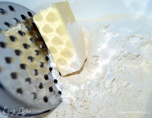 Муку просеять,масло натереть на крупной терке, добавить сахар, разрыхлитель и изюм. Перемешать.