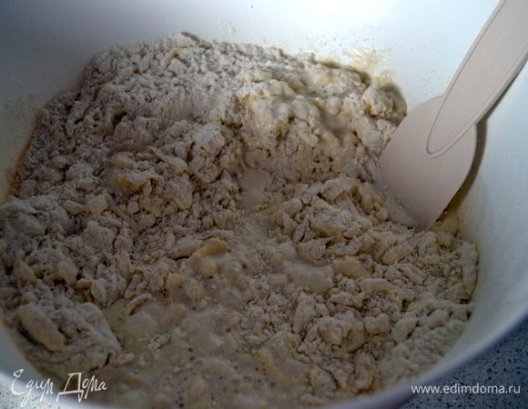 Влить молоко и сливки.Перемешать скребком до образования комковатой массы.