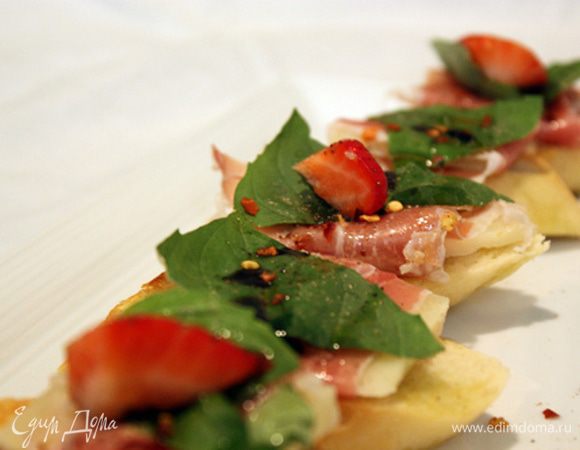 Гренку сбрызгиваем оливковым маслом и лимоном, ставим кусочек хамона с сыром, сверху базилик, а затем клубнику. Сверху снова поливаем соусом и присыпаем  молотым перцем.