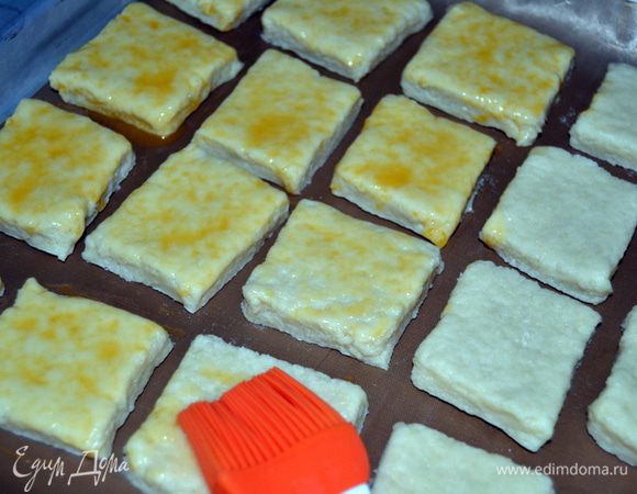 Переложить их на противень не очень близко друг к другу и смазать яйцом. Дать яйцу подсохнуть, затем еще раз смазать.