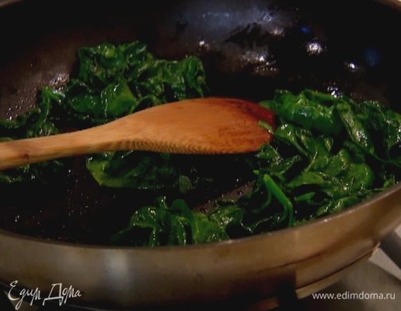 Разогреть в сковороде оливковое масло, выложить шпинат и слегка прогреть его на медленном огне, чтобы он поплыл.