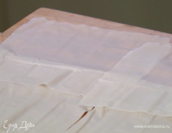 Каждый лист фило разрезать на 4 равные части, промазать прямоугольники теста растопленным сливочным маслом и сложить все вместе — должно получиться три четырехслойных пласта.
