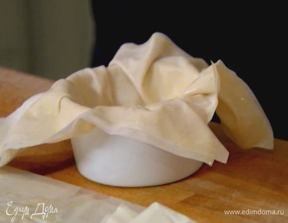 Каждый пласт смазать с одной стороны маслом и уложить в керамическую формочку смазанной частью вниз, так чтобы края теста свешивались — их тоже смазать маслом. 