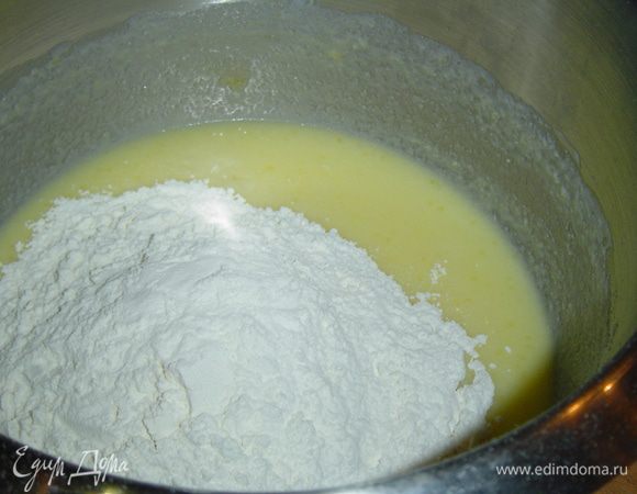 К яично-сливочной смеси добавляем просеянную муку и соду, перемешиваем.