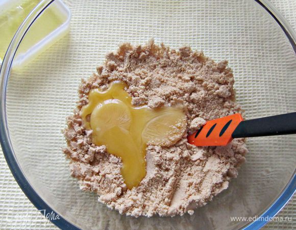 К измельчённому печенью добавить желтки и перемешать.