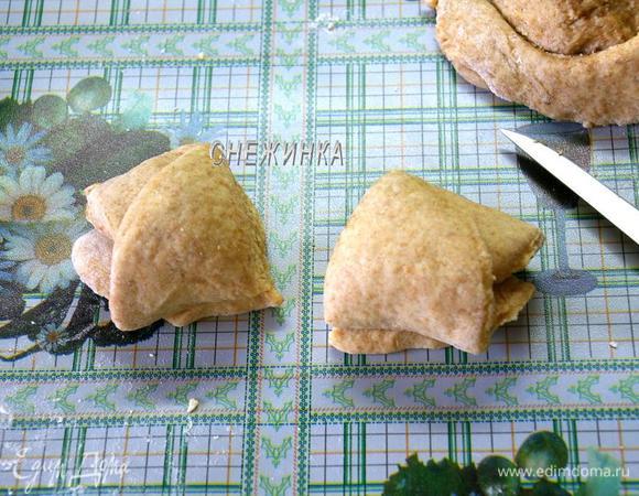 Сворачиваем рулетиком, начиная сбоку. Там, где круги соприкасаются друг с другом, проверяем, немного защипываем. Разрезаем рулетик пополам поперёк. Получается 2 булочки.