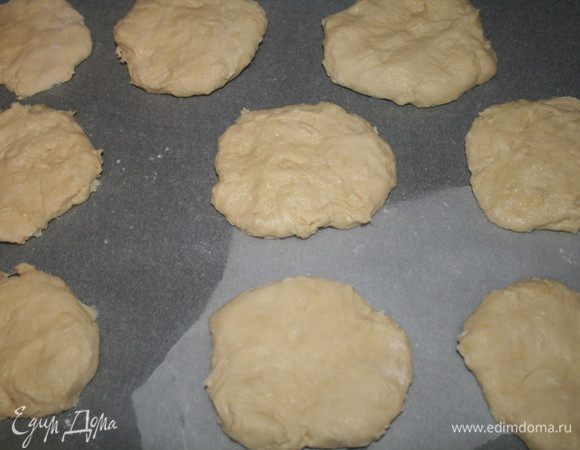 Слегка придавить шарик ладонью (ладонь можно чуть-чуть присыпать мукой, чтобы тесто не липло к рукам) и переложить лепёшечки на противень,застеленный пергаментом