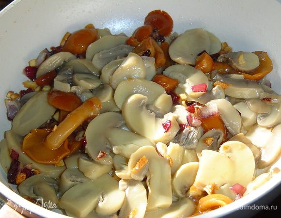 К луку и чесноку добавляем промытые шампиньоны и опята, тушим пять минут.