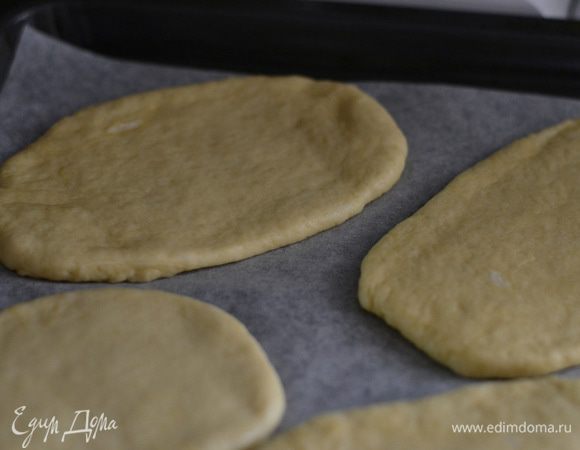 и раскатывать каждый кусок в круг или овал, толщина примерно в полсантиметра. Я раскатала разных размеров, скажу сразу, вкуснее, которые тоньше, они получились хрустящими, а внутри мягусенькие. Духовку предварительно разогреть на 220 градусов и выпекать около 20 минут до золотистого цвета. За 5 минут до готовности смазать каждую лепешечку смесью из оливкового или сливочного масло с укропом и чесноком посыпать кумином.