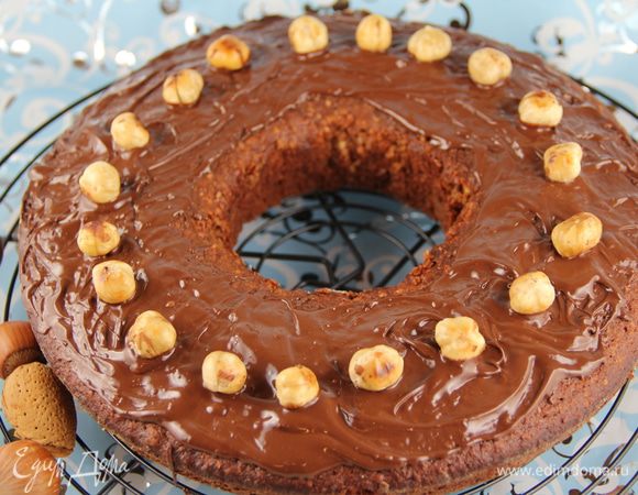 Для украшения растапливаем на водяной бане шоколад и поливаем или обмазываем им пирог. Или можно его полить шоколадной глазурью. Украшаем фундуком произвольно. 
