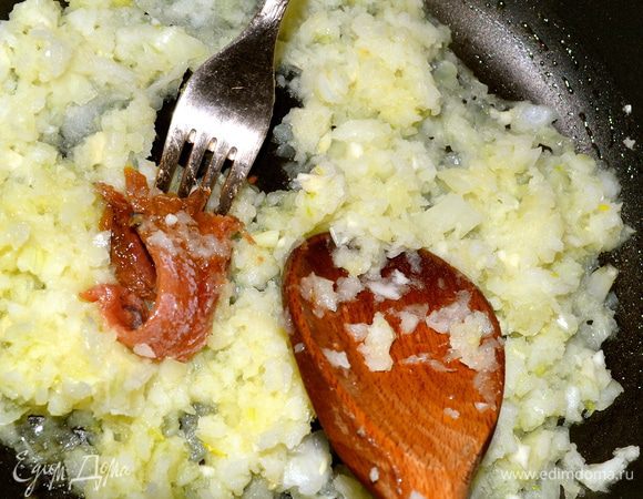 Лук мелко нарезать и поставить обжариваться вместе с анчоусами в небольшом количестве оливкового масла.