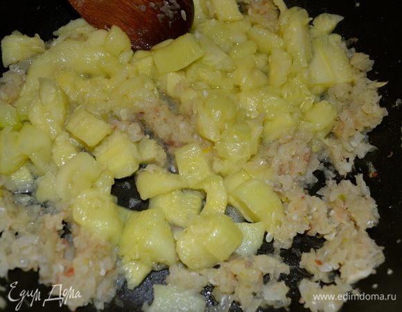 Удаленную мякоть нарезать и добавить к обжаривающемуся луку. Перемешать и подержать на огне еще пару минут.  
