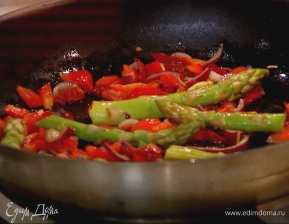 Когда лук станет золотистым, добавить спаржу и обжаривать еще пару минут.