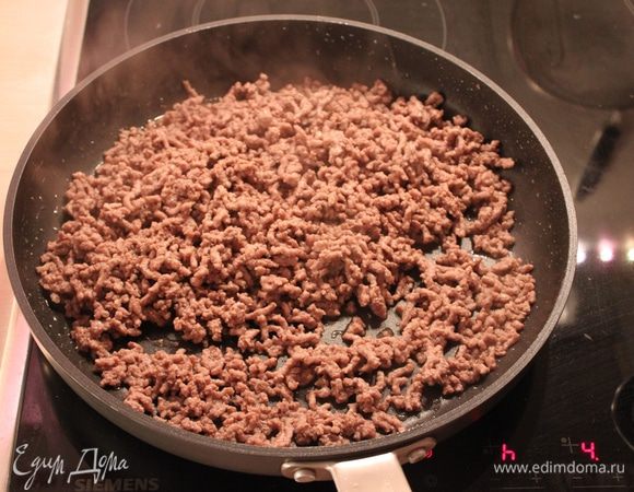 Фарш жарим до того момента, когда выпарится жидкость и фарш начнёт поджариваться. Добавить 300 мл воды или бульона, томаты в собственном соку, майоран, сахар, томатное пюре или пасту, хорошо посолить и поперчить. Добавить сюда лук+чеснок+перец. Довести до кипения, накрыть крышкой и тушить 20 мин. на медленном огне.