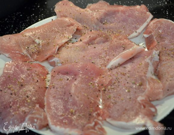 Посолить и поперчить свиные отбивные с 2-х сторон.
