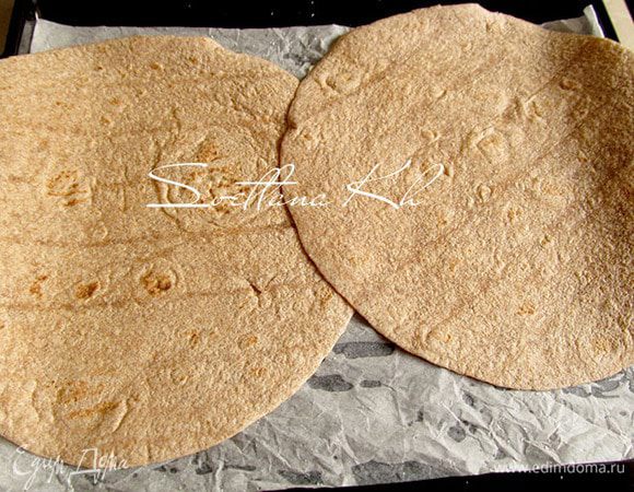 Противень застелить пергаментом, выложить лепешки тортильи.