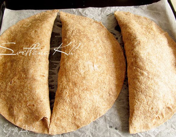 Края лепешек  по кругу смочить водой и свернуть пополам. Края плотно прижать пальцами и немного придержать. Краешки склеиваются, как вареники. Поставить противень с тортильями в  горячую духовку (190 гр.) и выпекать 10 минут до легкого зарумянивания. Подавать со сметаной.