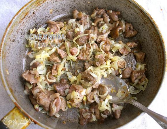 Прежде всего, я разморозила грибы. Можно взять и шампиньоны, но с лесными вкуснее, ароматнее. Варим грибы в подсоленной воде 25 минут. Сцеживаем, остужаем. На сковороде разогреваем растительное масло, лук чистим, нарезаем полукольцами и обжариваем на сковороде до прозрачности. Затем добавляем половину грибов, порезанных кусочками (можно крупными) и жарим 5 минут.