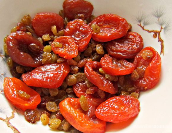 Изюм и курагу хорошо промыть и залить горячей кипячёной водой на 15 мин. Затем воду слить и обсушить курагу и изюм на бумажном полотенце.