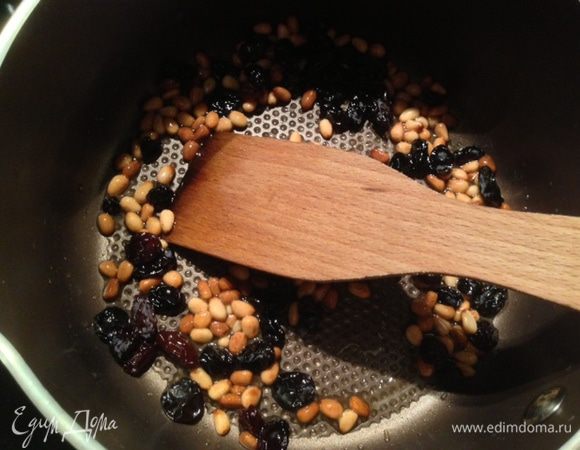 В сотейнике или кастрюле нагреть масло и на медленном огне поджарить кедровые орешки, часто перемешивая,  приблизительно минут 5,пока они не станут золотистого цвета. Добавить к орехам изюм и перемешивать 30 сек. 