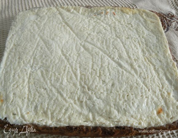 Достать бисквит из духовки. аккуратно перевернуть на полотенце. Снять пергаментную бумагу с бисквита.