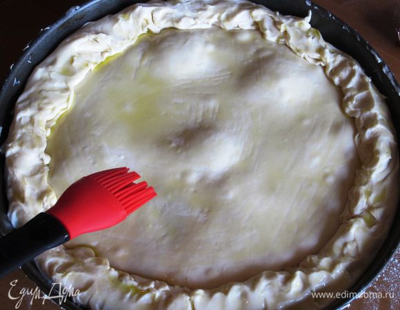 Поверхность пирога смазать оливковым маслом и выпекать в разогретой до 180°С духовке 60 - 65 минут.