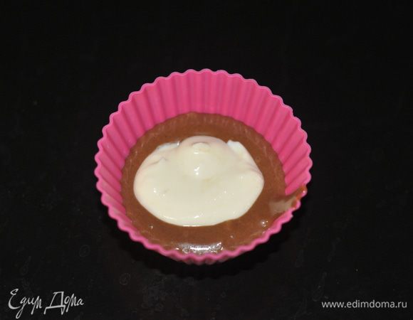 Формы для кексов смазать маслом и выложить в них по 1 ст. л. теста. Потом выложить 1 ч. л. творога и сверху ещё 1 ст. л. теста.