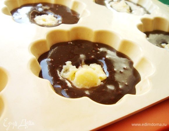 Формы для маффинов наполнить шоколадным тестом на 2/3. В середину каждого маффина положить по 1 ч.л.(с горкой) загустевшего заварного крема и немного утопить его.