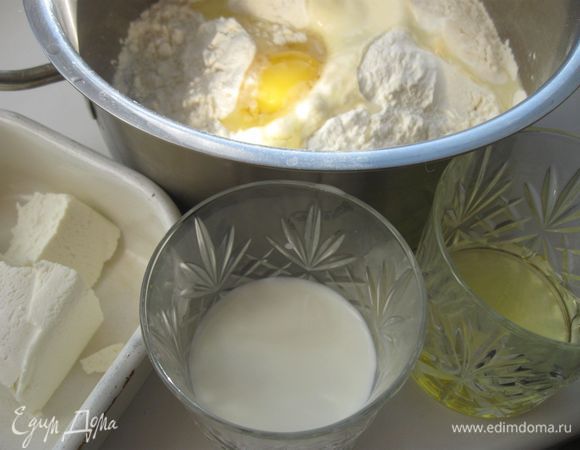 Хорошо перемешать молоко, творог, яйцо, оливковое масло, соль. Добавить просеянную муку и соду.