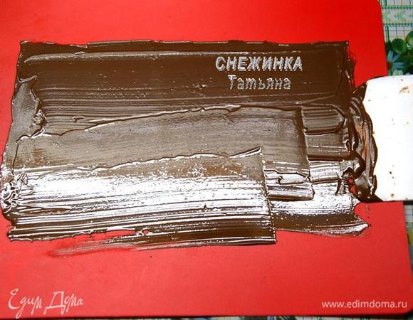 Для начала займёмся ШОКОЛАДНЫМИ УКРАШЕНИЯМИ. Их даже можно приготовить заранее, они хорошо хранятся в холодильнике, в контейнере с плотно закрывающейся крышкой. Итак, топим шоколад на водяной бане. Наносим тонкий слой шоколада при помощи шпателя на рабочую поверхность, у меня это гибкая доска, лучше же использовать мраморную или нейлоновую поверхность. Отправляем в холодильник, чтобы слой подзастыл. Нужно дождаться момента, когда шоколад перестанет быть мягким, но не затвердеет окончательно. Я поняла, что если, дотрагиваясь до шоколада, след пальца не остаётся, то он готов.