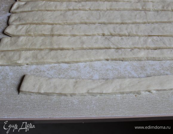 Тесто подошло... нам надо раскатать пласт толщиной в 0,6 см... и нарезать на полоски шириной 2,5 см... я делала потом жгуты.. но думаю, лучше надо делать полоски, просто потолще раскатывать...  и делать надо все быстро, потому что тесто подходит в процессе..