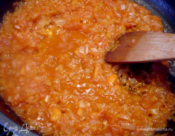 Готовим томатный соус. Помидоры кладем в кипяток буквально на две минуты и снимаем кожицу. Режем на небольшие кубики. Лук режем мелко. Обжариваем лук в оливковом масле пару минут, постоянно помешивая так, чтобы он не приобрел коричневого цвета, добавляем помидоры, томатную пасту и вливаем 125 мл горячей воды. Тушим 10 минут на среднем огне, время от времени помешивая. Вливаем еще 125 мл воды, солим и перчим по вкусу, перемешиваем.