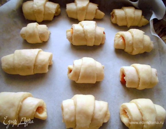 Сверните рогалики. После того как я свернула первый, я немного убрала начинки с остальных треугольников, т. к. она немного вылезала по краям. Но этого можно было и не делать, потому что, когда они «вырастут», тесто закроет края и начинка не вытечет. Накройте полотенцем и оставьте в теплом месте на 50–60 минут.