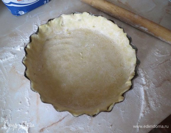 Муку просейте, смешайте с щепоткой соли и перетрите с маслом до состояния крошки. Добавьте яйцо и замесите гладкое эластичное тесто. Заверните в пленку и уберите на 40 минут в холодильник. Тесто раскатайте и выложите в форму с бортиками.