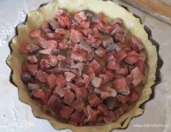 По тесту равномерно распределите жареный лук, сверху выложите рыбу.