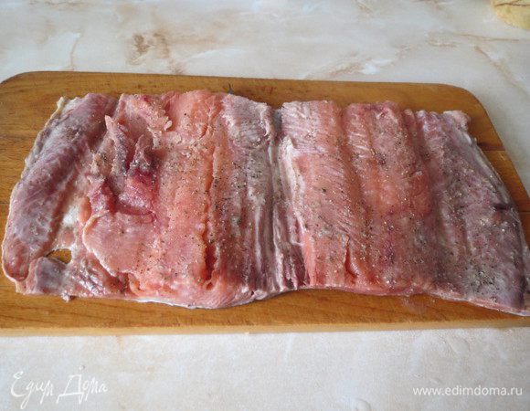 Рыбу распластываем на филе, удаляем косточки. Оставляем верхний плавник, чтобы 2 куска филе были соединены.
Солим, перчим, сбрызгиваем лимонным соком.