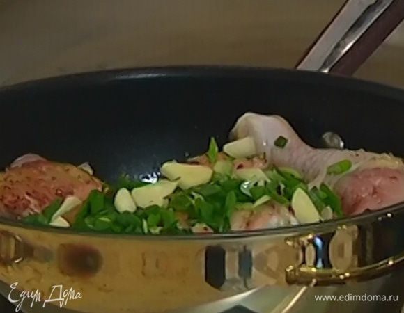 Лук и чеснок добавить к курице, перемешать и закрыть сковороду крышкой.