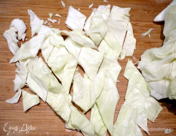 У капусты удаляем кочерыжку и жесткие прожилки. Режем листы капусты на полоски, которые разрезаем наискосок, получая ромбы, солим и слегка отжимаем, чтобы капуста дала сок.   
