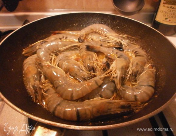 Тигровые креветки выкладываем на сковороду с разогретым  пропитанным чесноком и перцем маслом, вливаем остаток бренди, даём выпариться алкоголю, посолить. Креветки приобретут красный цвет. Через 4-5 минут они уже готовые. Убрать со сковороды только креветки и оставить соус. Добавить несколько капель бальзамического уксуса и сразу снять с огня.