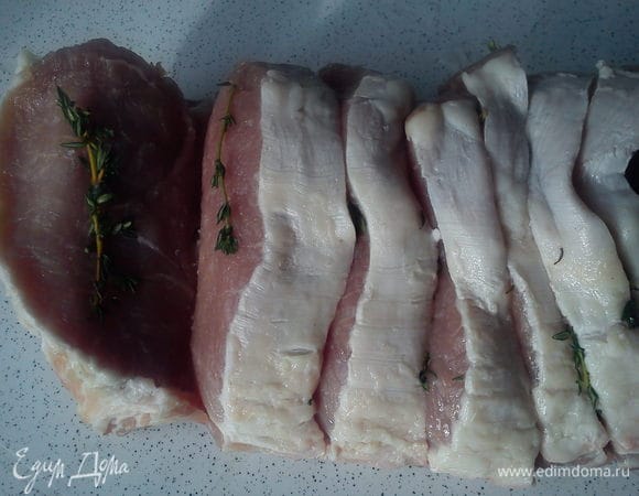 Мясо разрезать на куски между ребрами не дорезая до конца 1 см. Размер кусочка зависит от ширины ребра. Каждый кусочек должен быть на ребрышке.
Посолить, поперчить и выложить на каждый кусочек по 2-3 веточки тимьяна с каждой стороны.