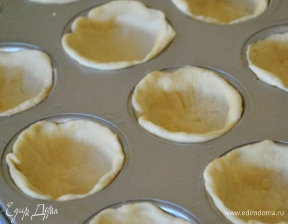 Тесто разделить на 12 равных кусочков, каждый скатать в шарик, затем сформировать лепешечку и уложить в форму для маффинов (ее предварительно смазать маслом).